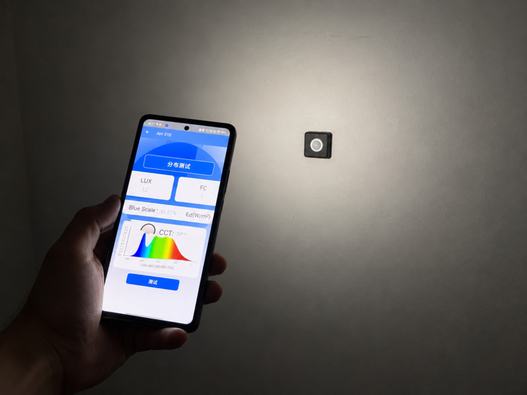 Smartphone flashlight test setup with the beam aimed at a wall-mounted light sensor